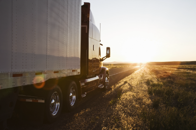 A truck driving into the sunset